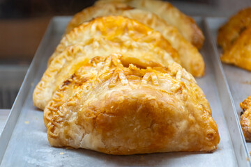 Traditional Spanish and Latin American pies empanadas with different fillings, at farmer's market in bakery