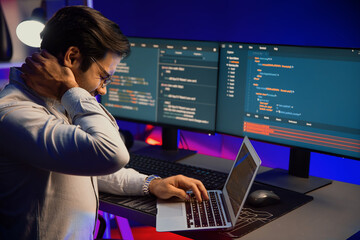 IT developer being tried of overwork on solve problem in error software coding system with sitting...