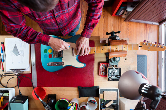 Technician fixing electric guitar