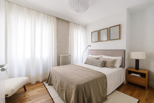 Fototapeta A minimalist bedroom with a bed featuring beige linens