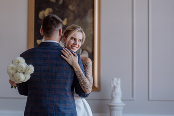 A beautiful young couple, the bride and groom, are standing in an embrace. Family. Wedding. Marriage