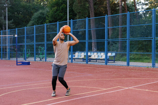 Athlete executing set shot on court during basketball workout