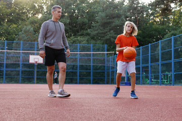 Student making set shot on court under supervision of basketball coach
