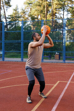 Basketball player making set shot while standing on outdoor court