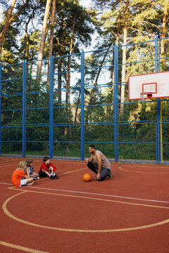 Basketball coach giving instructions to his students during workout