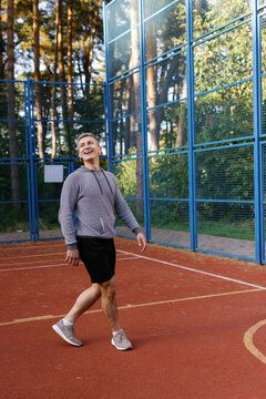 Coach moving around outdoor basketball court during game