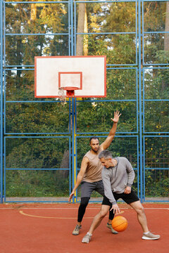 Defender trying to block path of offensive player dribbling basketball