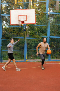 Offensive player dribbling basketball chased by defender during game