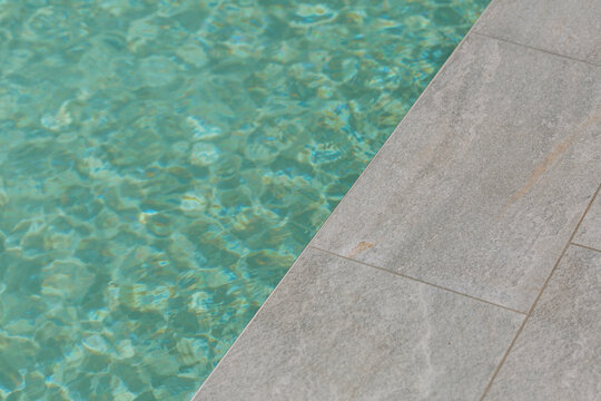 Swimming pool with blue water and stone deck edge