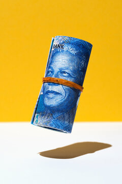 South African rand money roll hovering on yellow and white background