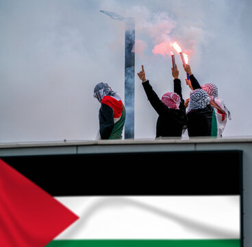 An anonymous march holding torch and Palestinian flags