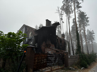 A heavily damaged house in Hostomel, Kyiv region, its exterior blackened by fire and structural...