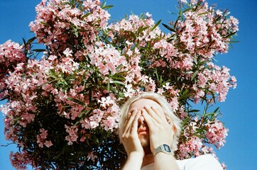 A young man by the pink blossom tree