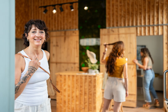 Smiling woman entering a zero waste shop with sustainable products