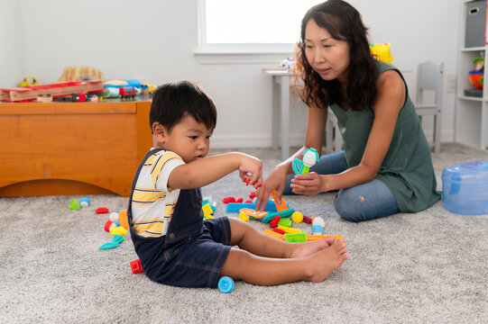 Boy plays with toys in playroom