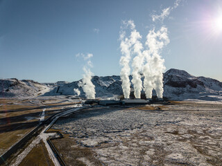 White steam billows from the geothermal power plant in Hellisheidi, Iceland, contrasting with the...
