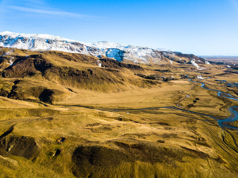 Scenic aerial panorama showcases the Hveragerdi geothermal area in Iceland, highlighting majestic mountains and bubbling hot springs. Natural beauty captivates with vibrant geothermal activity
