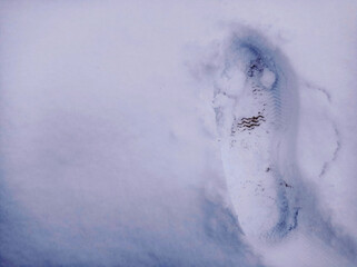 Footprint in the snow . Human footprint in white snow, free space. Footprints from boots in the snow.