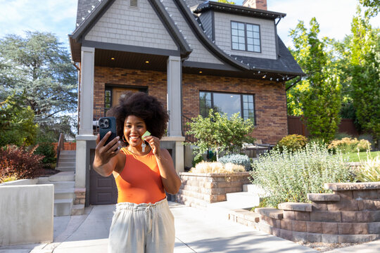 Proud young black woman portrait with key to new home 