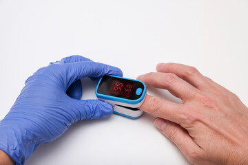 Doctor measures the patient's pulse and oxygen saturation to a patient
