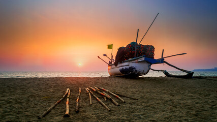 Colorful Panoramic view of a beach sunset  sunrise with a fishing boat on the sand in Arossim Beach Goa India