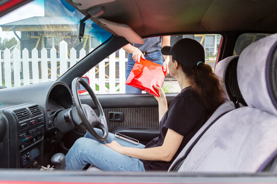 Courier Receiving Envelope from Customer Through Car Window