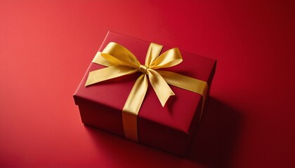 Fototapeta premium A beautifully wrapped red gift box with a golden ribbon and bow.