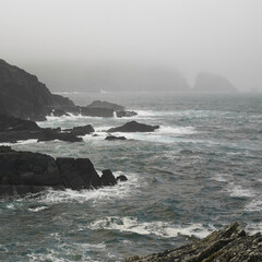 waves crashing on cliffs on a rainy day on the West coast of Irland