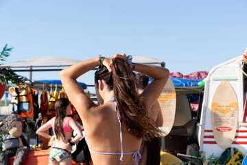 Girl Fixing Hair at Beach Equipment Rental Stall