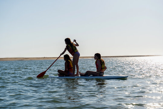 Girls Paddleboarding on Calm Ocean