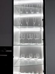 Glass cabinet with different glasses and glasses, all illuminated by a built-in panel