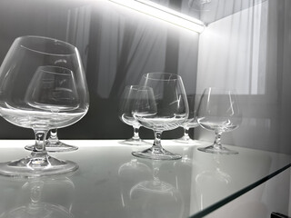 Glass cabinet with different glasses and glasses, all illuminated by built-in lighting