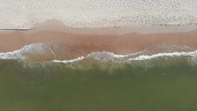 Morskie fale na piaszczystej plaży w słoneczne popołudnie, zwolnione tempo