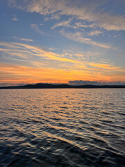 sunset on the lake, orange sunlight reflecting in the water, beautiful evening sunset