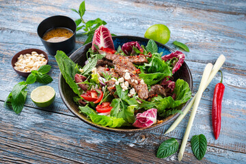 Mixed Thai style green leafy Salad with marinated beef and peanuts served with vinaigrette dressing...