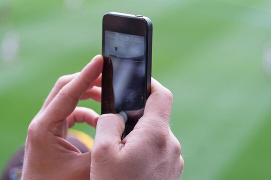 Person using a smart phone at a sports stadium