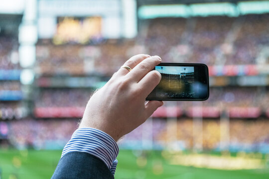 Person taking photos during a footie game at MCG