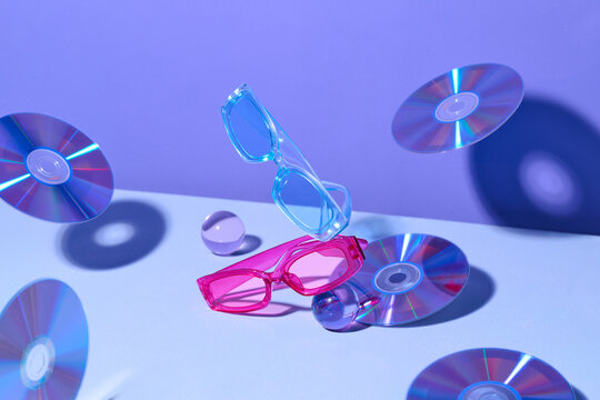 Colorful Sunglasses and Floating CDs on Purple Background