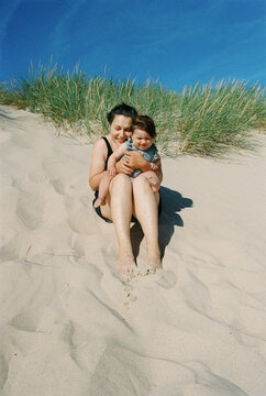 Mother and one year old daughter on the sand 