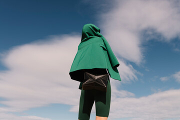 Fashionable Woman in Green Outfit Against Blue Sky
