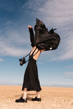 Stylish Woman In Black Dress On Sandy Beach