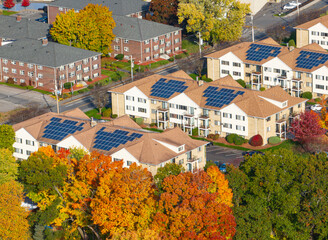 aerial view of community with solar panel installed on apartment building roof 