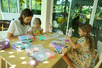 Teacher in workshop teched two girls how to assemble a thermo mosaic 