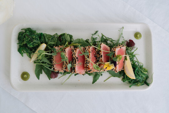 Freshly seared tuna salad with greens and garnishes.