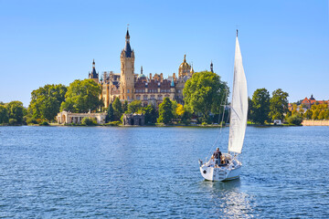 Schöner Blick auf das berühmte Schweriner Schloss, mit Segelboot im Vordergrund, in Deutschland, Mecklenburg-Vorpommern.