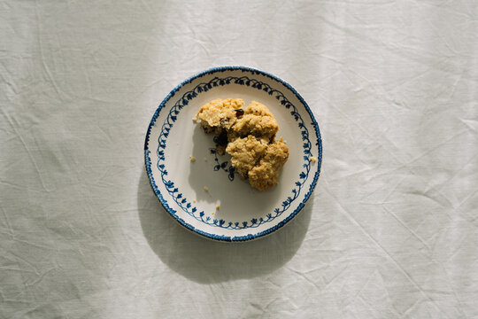 Partially eaten cookie on a decorative plate, above view.