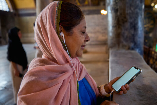 Woman Using Mobile Audio Guide in Historic Building