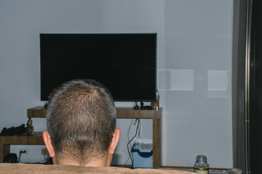 Man Sitting on Sofa at Home 