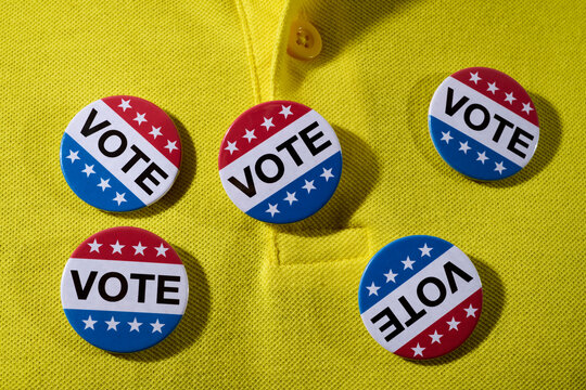 vote badges pinned on his polo shirt