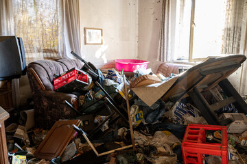 Chaos im Wohnzimmer einer Messie-Wohnung mit Sonnenlicht